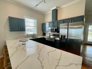 a kitchen with a stainless steel refrigerator and black cabinets at Sunflower Mama in St. George Island