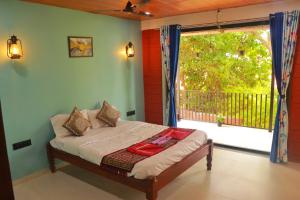 a bedroom with a bed and a large window at Orchid View Villa Mahabaleshwar 2 Bhk Villa in Mahabaleshwar