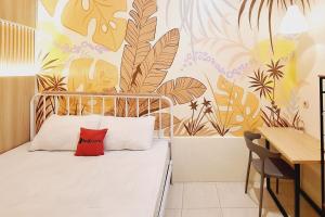 a bedroom with a bed with a red pillow on it at Reddoorz New Melati near Stasiun Blitar in Blitar