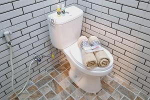 a bathroom with a toilet with towels on it at Reddoorz New Melati near Stasiun Blitar in Blitar +41 photos