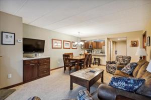 a living room with a couch and a table at Pinnacle F01 in Killington