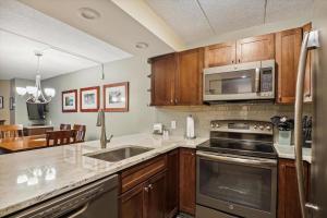 a kitchen with stainless steel appliances and wooden cabinets at Pinnacle F01 in Killington
