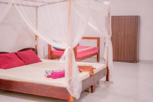 a bedroom with two beds with mosquito nets at Monkey villa in Hikkaduwa