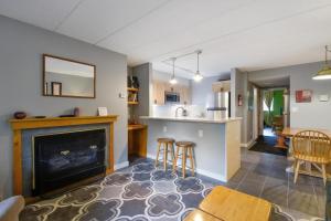 a kitchen and living room with a fireplace and a table at Pinnacle E15 in Killington