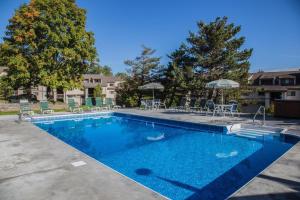 a large swimming pool with chairs and umbrellas at Pinnacle E15 in Killington