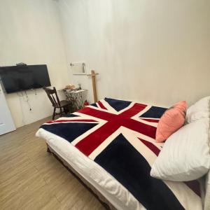 Una cama con una manta de bandera británica. en 台南包棟民宿 灰熊人文-預訂後聯繫才會保留, en Tainan