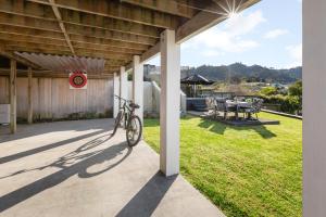 a bike parked on the side of a patio at Two Palms - Waihi Beach Holiday Apartment in Mangonui +10 photos