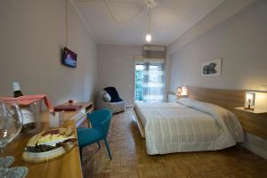 een slaapkamer met een bed, een tafel en een stoel bij Ciauru Design B&B in Messina