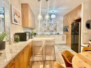 a kitchen with wooden cabinets and a table and chairs at Knightsbridge Luxury Escape in Cape Town