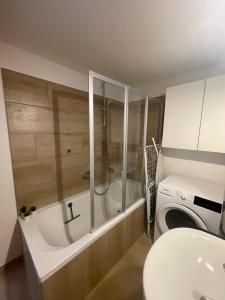 a bathroom with a tub and a washing machine at Fewo Bergstories in Wald am Arlberg +62 photos