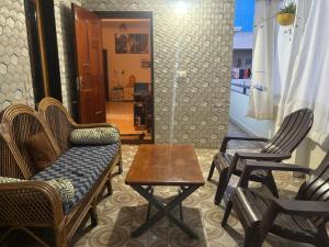 a living room with chairs and a table and a door at Seven Peak Hostel in Chikmagalūr