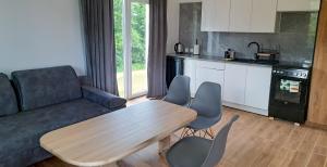 a living room with a couch and a table and chairs at Domki Gaładuś in Radziucie