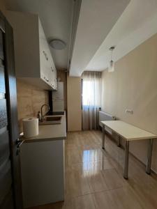 a kitchen with a sink and a table in a room at Apartament in Craiova +1 photo