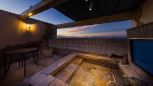 a patio with a fireplace and a table with a view at Hotel Crespa in Shizuoka
