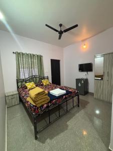 een bed in een kamer met een plafondventilator bij Tamasha Goa Vagator in Vagator