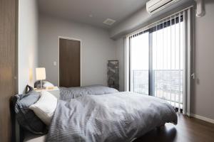 a bedroom with two beds and a large window at Buena Vista Ohori Park in Fukuoka