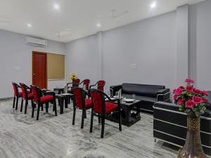 a conference room with red chairs and tables and a podium at Super Super Townhouse Swaroop Inn in Chinhat