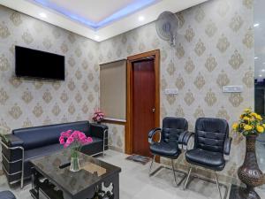 a waiting room with a couch and chairs and a tv at Super Super Townhouse Swaroop Inn in Chinhat