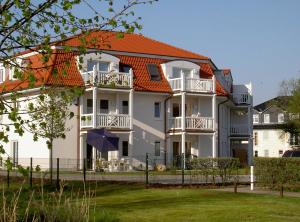 a large white house with an orange roof at Residenz Strandkrone 09 in Kühlungsborn