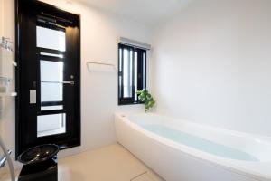 a white bathroom with a tub and a window at Buena Vista Ohori Park in Fukuoka +264 photos