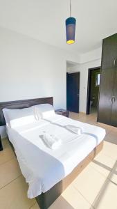 a large white bed in a room with a light at Palmvibes Villa in Paralimni