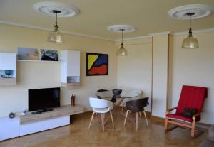 a living room with a tv and a table and chairs at Acogedor piso con vistas en Sada in Sada