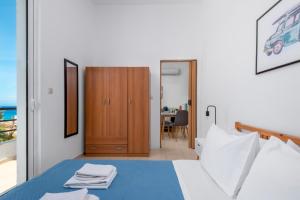 een slaapkamer met een bed en een houten kast bij Sea Apartment Ixia Ialisos in Ialyssos