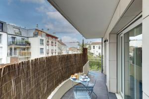 eine Terrasse mit Tisch und Stühlen auf einem Balkon in der Unterkunft Suite Dolce Vita - Superbe Appartement in Suresnes