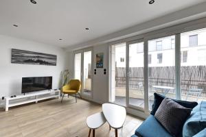 ein Wohnzimmer mit Sofa und Fernseher in der Unterkunft Suite Dolce Vita - Superbe Appartement in Suresnes