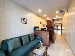 a living room with a green couch and a counter at Hotel Sunny Cot - Free Mall Shuttle and Parking in Mussoorie