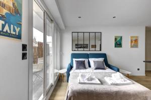 Schlafzimmer mit einem Bett mit blauem Kopfteil in der Unterkunft Suite Dolce Vita - Superbe Appartement in Suresnes