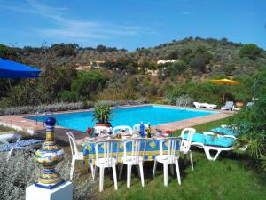 a table and chairs in front of a swimming pool at Hotel Casa Grande in Constantina