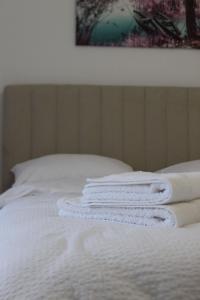 three white towels stacked on top of a bed at Apartmani Grot Pale in Pale +41 photos