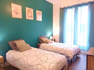 two beds in a room with blue walls at Plein centre- 90m Cathédrale - 2ch - 4 couchages - 6 personnes in Amiens