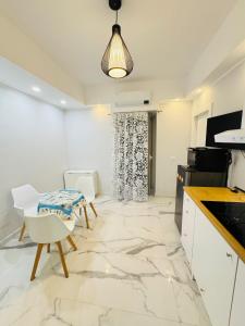 a kitchen with white cabinets and a table and chairs at Limoni Inn Messina in Messina +45 photos