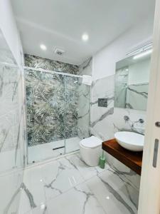 a bathroom with a shower and a toilet and a sink at Limoni Inn Messina in Messina