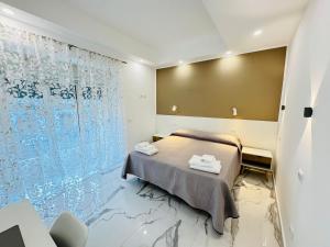 a bedroom with a bed and a glass wall at Limoni Inn Messina in Messina