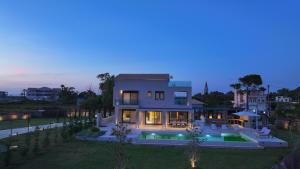 a large house with a swimming pool at night at Aquamarina Villas in Lefkada Town