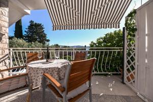 taras ze stołem i krzesłami na balkonie w obiekcie Apartment Rajna w Biogradzie na Moru