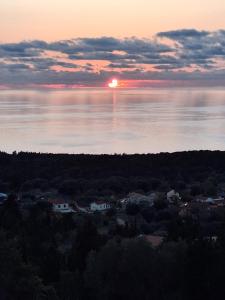 a sunset over a body of water with houses at Belle View Hotel - Sea View & Sunset in Mánganos