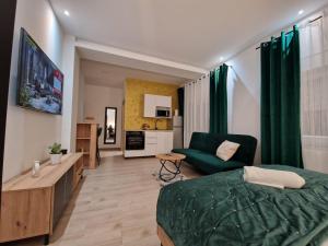 a bedroom with a green bed and a living room at Apartment Luxury B in Slavonski Brod