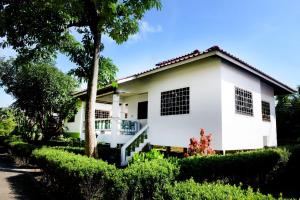 a white house with a tree in front of it at Sunrise Beach Villa in Ban Bang Po +3 photos