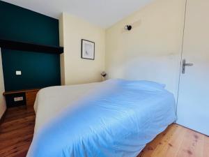 a bedroom with a bed with a blue blanket at T3 au cœur du centre historique de Briançon #6 in Briançon