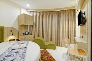 a bedroom with a bed and a desk and a tv at Hotel M Park in Gandhinagar