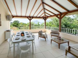 una sala da pranzo con tavolo e sedie su un balcone di Bel appartement duplex T4 Laboté, vue mer, a 600m de la plage de Diamant a Le Diamant