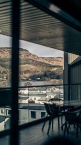 a balcony with a table and chairs looking out a window at Loch Earn leisure park in Saint Fillans +4 photos