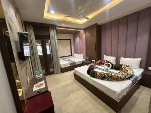 a hotel room with two beds and a television at HOTEL PREMIER CHOICE - JUST 50 Meters FROM AJMER SHARIF DARGAH in Ajmer