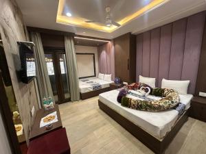 a hotel room with two beds and a television at HOTEL PREMIER CHOICE - JUST 50 Meters FROM AJMER SHARIF DARGAH in Ajmer