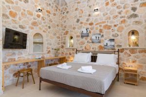 a bedroom with a bed and a stone wall at Villa Mezzo Suite by Villa Plus in Skinária