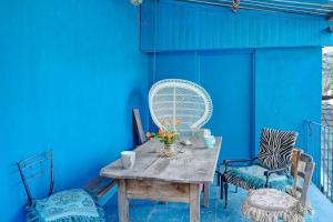 a blue wall with a wooden table and chairs at Room in the Country House in Argallo